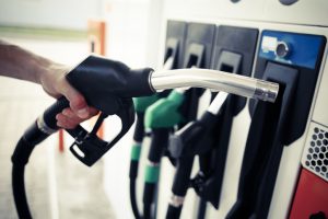 Detail of a hand holding a fuel pump at a station